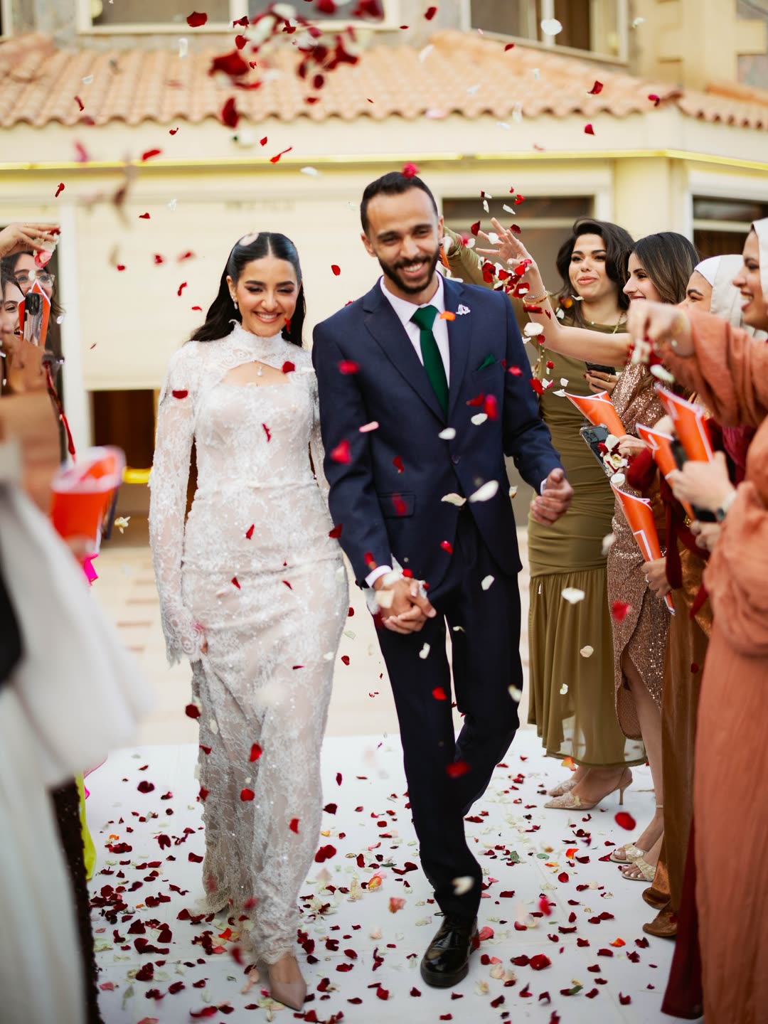A couple under falling petals at their wedding