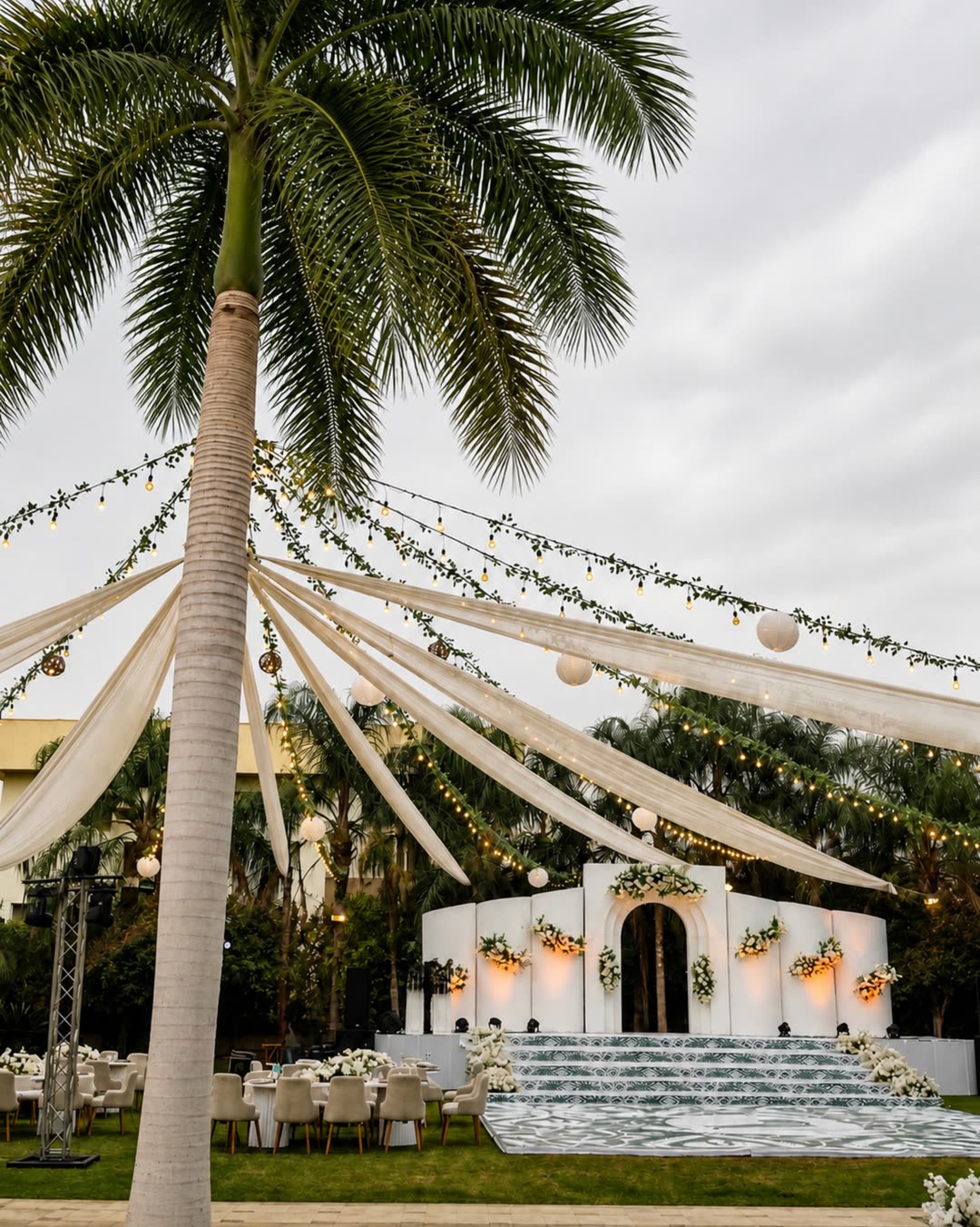 White ceremony stage framed by palms
